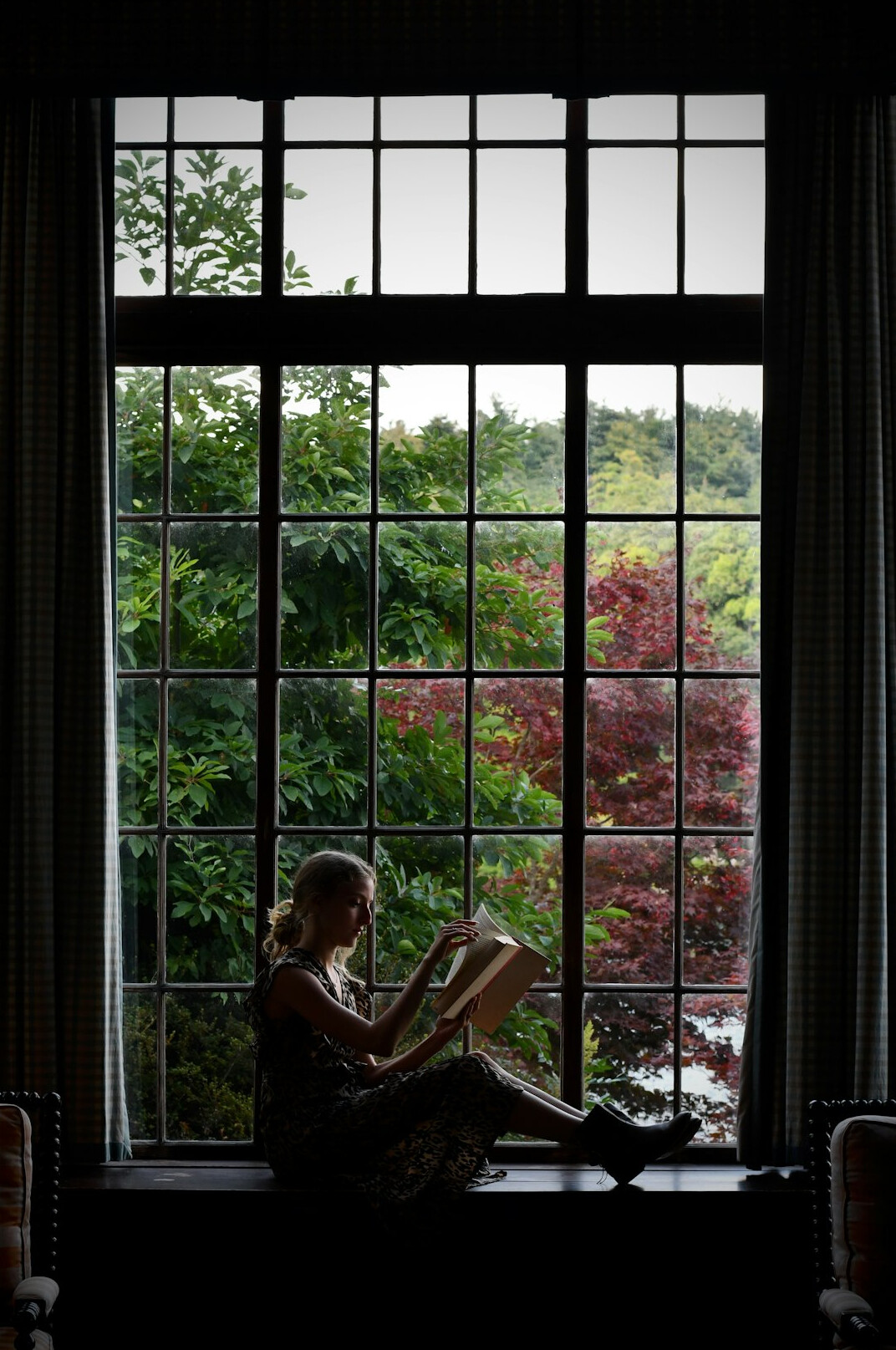 person reading book by window